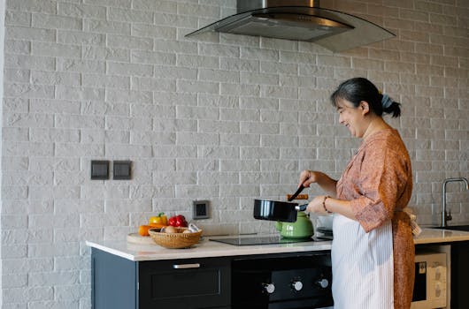 a woman sautéing vegetables in a pan